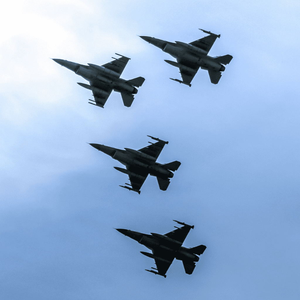 Four fighter jets in formation flight against a cloudy sky.